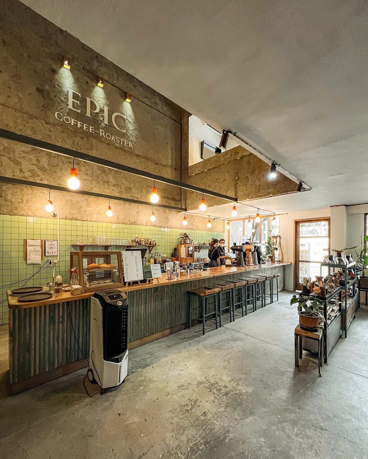 The café's bar counter, warmly lit under the EPIC COFFEE ROASTER wall lettering