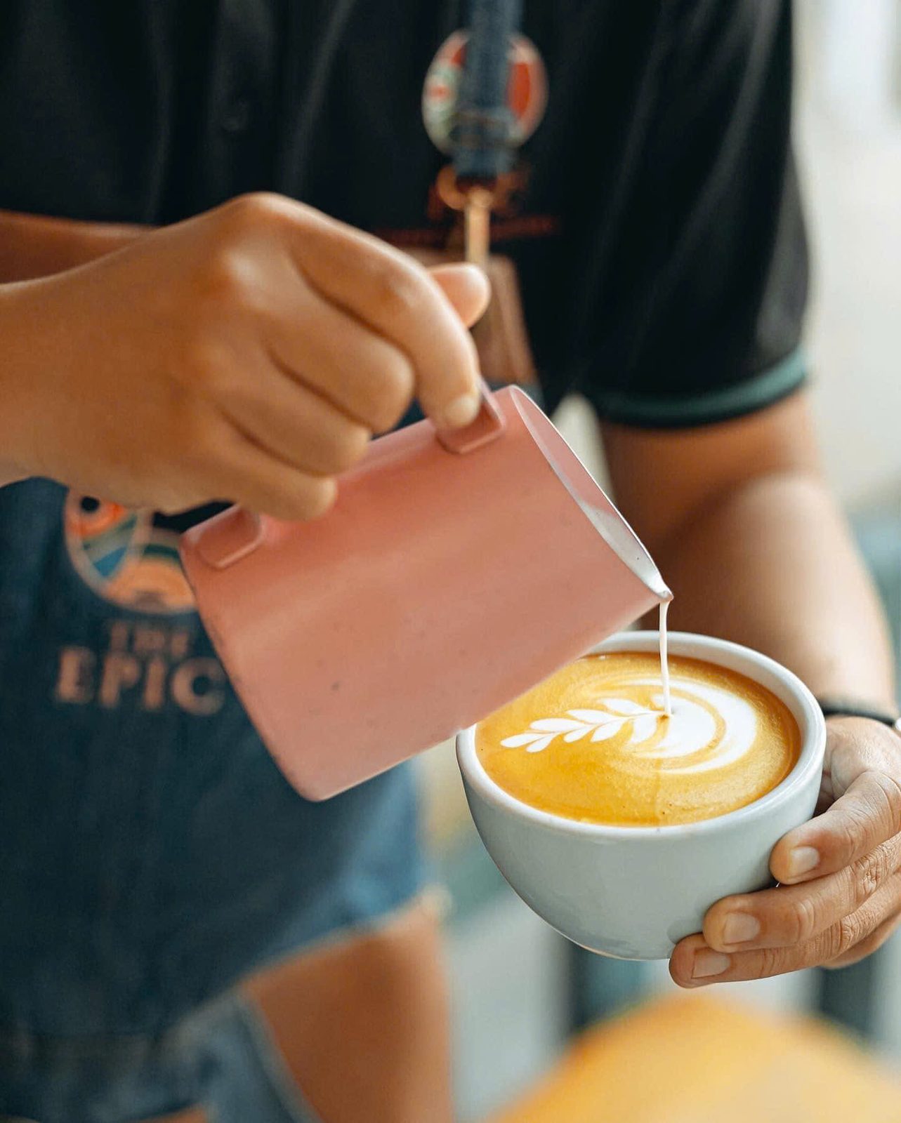 A barista pouring a latte