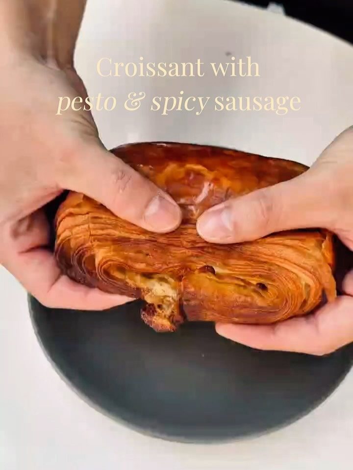 Croissant with pesto and spicy sausage, layers in close-up