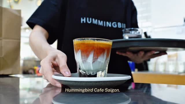A barista at the bar, geotagged “Hummingbird Cafe Saigon”