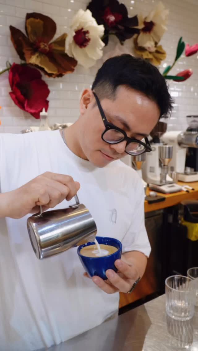 A barista mid-pour, portrait framing