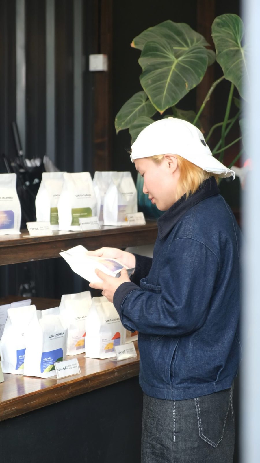 A customer reading a bean card by the shelf