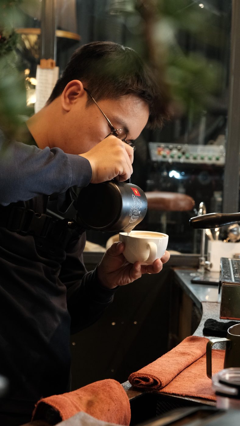 A barista dialling in a brew